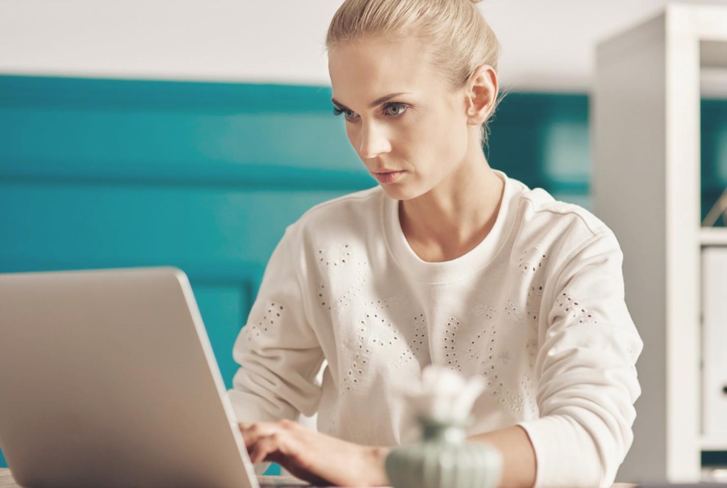Financial analyst reviewing detailed spreadsheet models with charts and projections on dual monitors